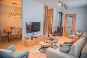 a living room with a couch and a tv and a table at Mountain angels in Kolašin