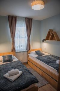sypialnia z 2 łóżkami i oknem w obiekcie Mountain angels w mieście Kolašin