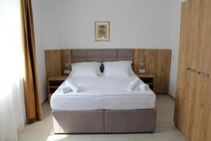 1 dormitorio con 1 cama grande con sábanas blancas en Royal Apartmani en Banja Luka