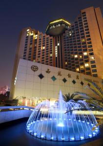 uma fonte em frente a um edifício à noite em Xiyuan Hotel em Pequim