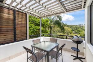 balcón con mesa, sillas y vistas en Bella Casa Noosa, en Noosa Heads