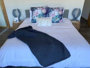 a bed with a black blanket and pillows on it at Yarra Valley Country Escape in Yarra Junction