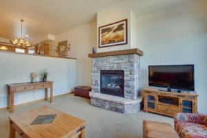 a living room with a fireplace and a flat screen tv at Bear Crossing 845 in Winter Park