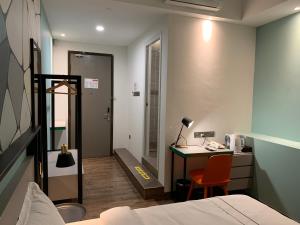 a hotel room with a bed and a desk and a desk at K Hotel in Kota Kinabalu