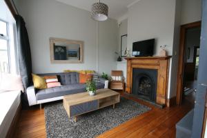 uma sala de estar com um sofá e uma lareira em Kingwell Cottage - New Plymouth Holiday Home em New Plymouth