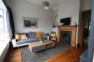 a living room with a couch and a fireplace at Kingwell Cottage - New Plymouth Holiday Home in New Plymouth