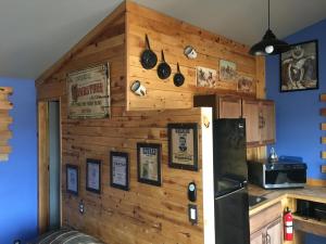 a kitchen with a wooden wall with a refrigerator at KMJ Rentals in Congress