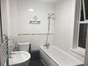 a bathroom with a tub and a toilet and a sink at Lovely 1 bedroom flat High Barnet 3 mins away in Barnet