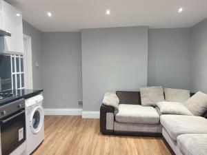 a living room with a couch and a dishwasher at Lovely 1 bedroom flat High Barnet 3 mins away in Barnet