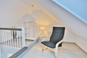 a black chair sitting in a room under the stairs at Villa Meeresstrand Villa Meeresstrand Appartement 10 in Haffkrug