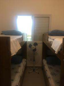 Zimmer mit 3 Etagenbetten und einem Ventilator in der Unterkunft Apartamento Bertioga Torres in Bertioga + 22 Fotos