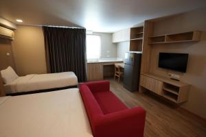 a hotel room with a bed and a red chair at Baan Tanwa - MRT Ratchadapisek in Bangkok