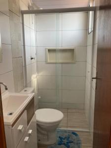 y baño con aseo, lavabo y ducha. en Enseada encantada, en Porto Belo