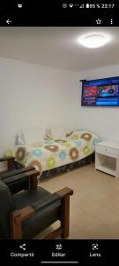 Cama en habitación con sofá y mesa en Casa Blanca, en Villa Rumipal