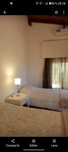 una habitación con dos camas y una mesa con lámpara en Casa Blanca, en Villa Rumipal