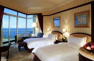 a hotel room with two beds and a large window at The Empire Brunei in Bandar Seri Begawan