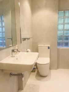 a white bathroom with a sink and a toilet at Beach Lodge in Auckland