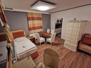 ゲラスドルフ・バイ・ウィーンにあるPension Föhrenhainのベッドとダイニングルームが備わる小さな客室です。