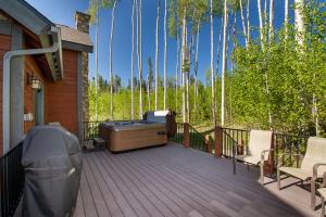 a deck with a hot tub and chairs on a house at Leland Creek Home in Winter Park
