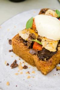 a piece of bread with meat and vegetables on a plate at ARTOTEL Haniman Ubud in Ubud