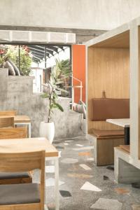 a room with a table, chairs, and a bench at Artotel Haniman Ubud in Ubud
