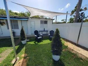 a patio with a table and chairs and a fence at Aguadilla Breeze apt in gated complex 8 minute walk to Crashboat beach in Aguadilla