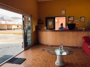 a coffee table in front of a bar with a person at Hotel Rio Inn in Veracruz