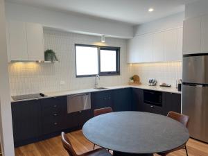 een keuken met een tafel met stoelen en een raam bij 13th Beach Golf Lodges in Barwon Heads