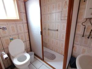 アンクードにあるDepartamentos y Cabañas Ancudのトイレ、シャワー、洗面台を備えたバスルーム +15枚の写真