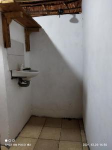 ein Bad mit einem Waschbecken in einer weißen Wand in der Unterkunft Mida Creek Eco Camp - relax in cosy cottage in Mida