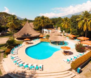 an aerial view of a resort pool with chairs and umbrellas at Hotel y Spa Santa Fe Colonial in Santa Fe de Antioquia
