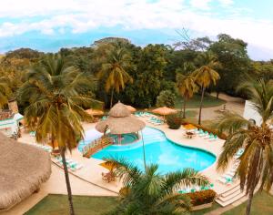 - une vue aérienne sur la piscine du complexe bordée de palmiers dans l'établissement Hotel y Spa Santa Fe Colonial, à Santa Fe de Antioquia