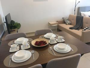 un soggiorno con tavolo in legno e piatti bianchi di Midhill Service Aparment Genting Highlands a Resorts World Genting