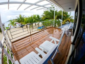 a balcony with white chairs on a cruise ship at Lagoon View Maldives in Bodufolhudhoo