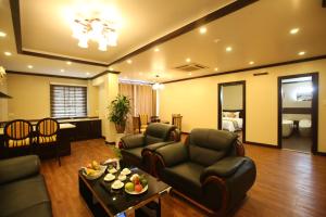 a living room with two couches and a table at Lac Long Hotel Hai Phong in Hai Phong