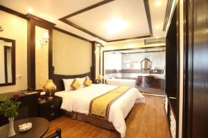 a hotel room with a bed and a bathroom at Lac Long Hotel Hai Phong in Hai Phong