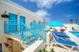 Villa con piscina y barandilla azul en Sunny Hill Hotel Apartments, en Pafos