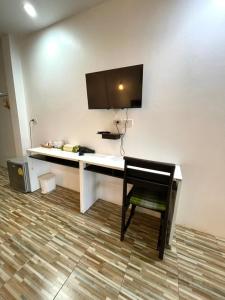 考索Khaosok Good view Resort - SHA PLUS的一张桌子、一把椅子和一台挂在墙上的电视