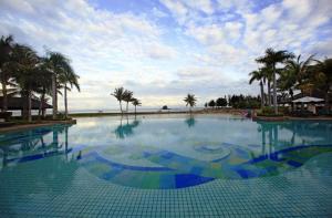a large swimming pool with the ocean in the background at The Empire Brunei in Bandar Seri Begawan