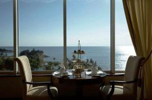 a table and chairs in a room with a view of the ocean at The Empire Brunei in Bandar Seri Begawan