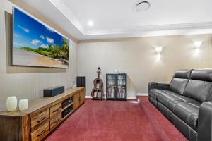 a living room with a couch and a guitar at Casa Bella 3 Bedroom in Coffs Harbour