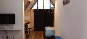 a living room with a staircase and a television at Farmstay in ചില്ലുകൂടാരം at Les Domki et al. in Vagamon