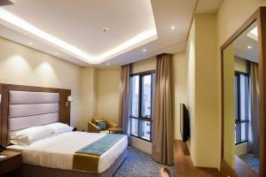 una camera d'albergo con un letto e una grande finestra di ROZANA HOTEL a Mascate