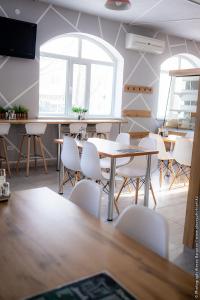 AS Inn Hotel في كاراغاندي: غرفة طعام مع طاولات وكراسي بيضاء
