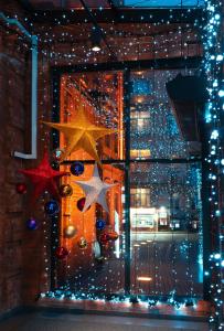 ein Fenster mit Weihnachtslichtern und Sternen in der Unterkunft AZIMUT Hotel Tulskaya Moscow in Moskau