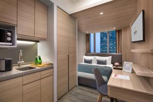 a hotel room with a bed and a sink and a desk at Modena by Fraser Hong Kong in Hong Kong