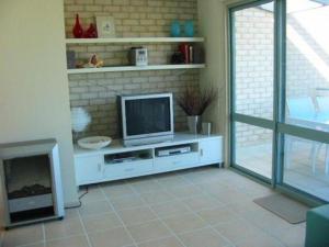 a living room with a tv and a fireplace at Sandy Place on Long Beach in Long Beach