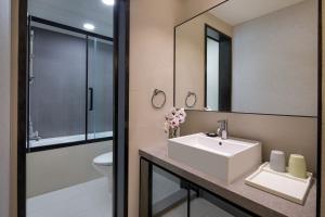 uma casa de banho com um lavatório, um WC e um espelho. em Modena by Fraser Hong Kong em Hong Kong