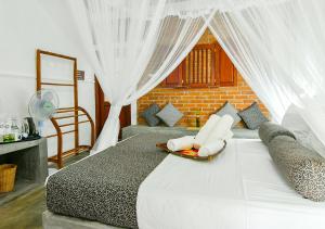 a bedroom with a bed with white curtains at Thotupola Residence in Kandy