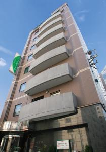 un grand bâtiment avec un panneau sur son côté dans l'établissement Hotel Green Mark, à Sendai